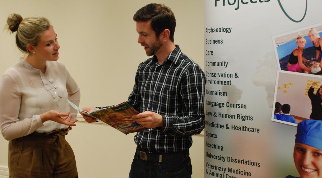 A Projects Abroad staff member answers questions about volunteering during a London event. A prospective volunteer talks to a Projects Abroad staff member at an event in London.